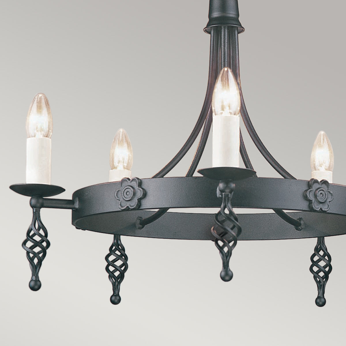 Détail des bras décoratifs et des fleurs en fonte noire