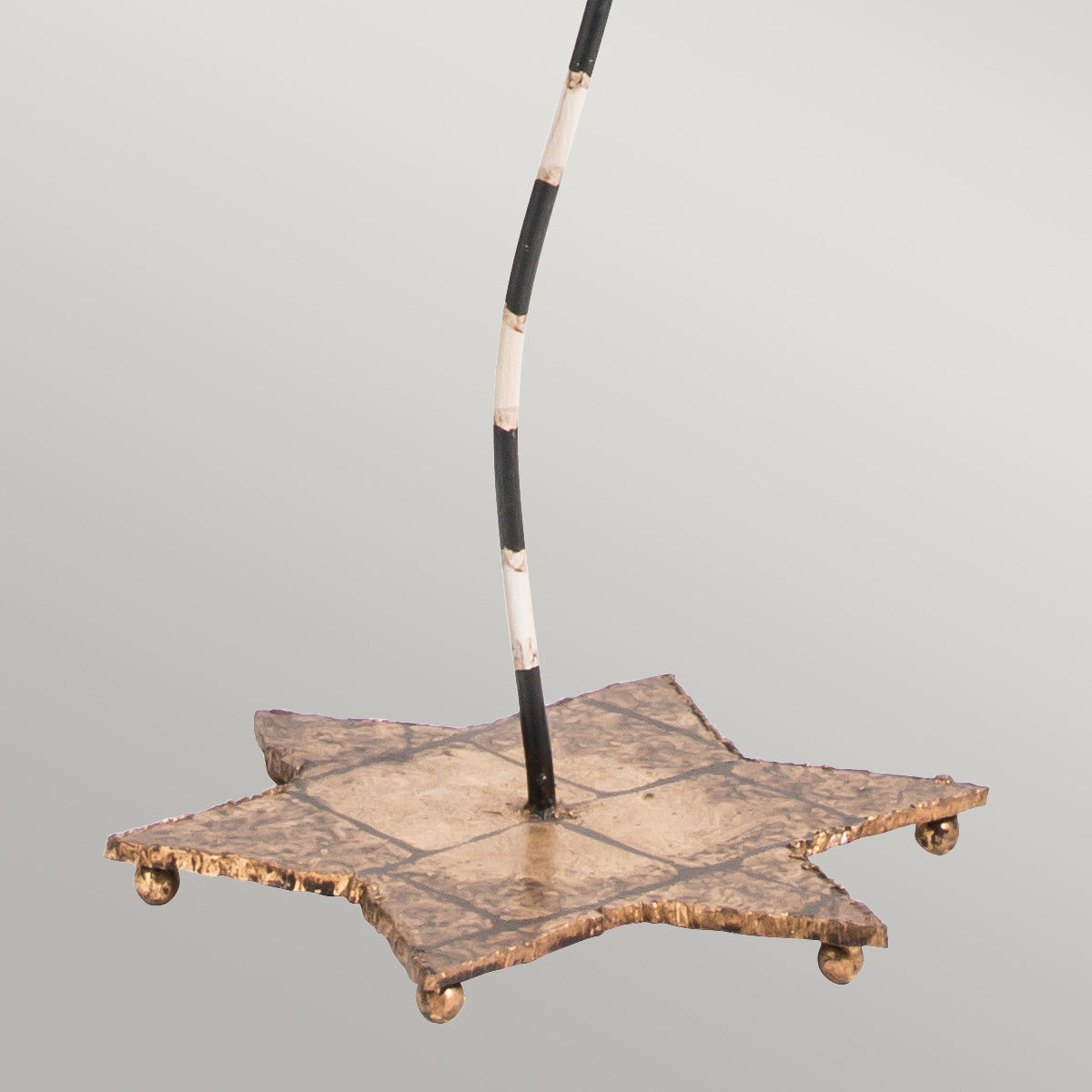 Base en forme d'étoile dorée avec petits pieds à roulettes et tige noire.