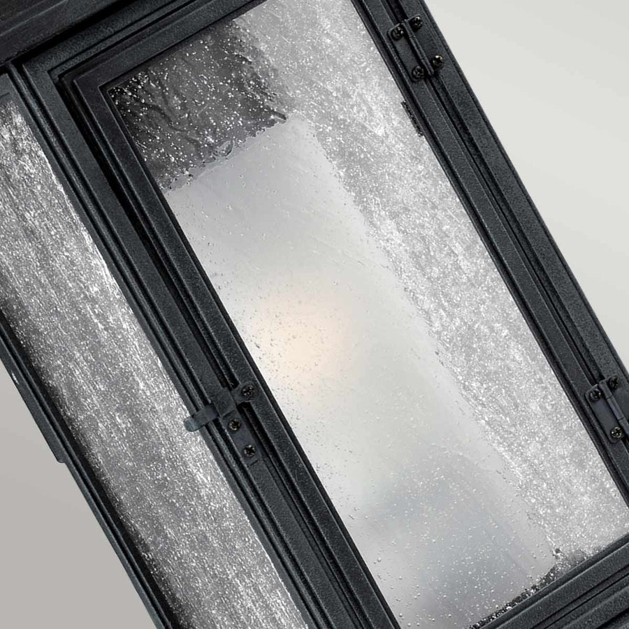 Gros plan sur le verre granité et la porte vitrée avec charnières noires.