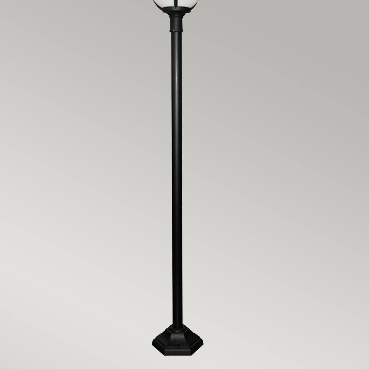 Vue rapprochée du bas du lampadaire, mât noir et embase hexagonale.