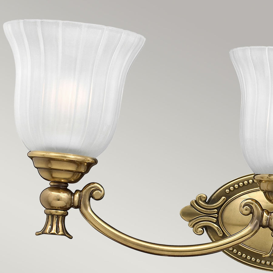 Gros plan sur le bras courbe, la coupelle et le verre dépoli d'une lumière.