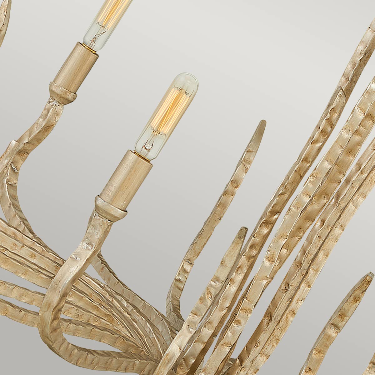 Gros plan sur les branches martelées et les douilles dorées avec ampoules à filament