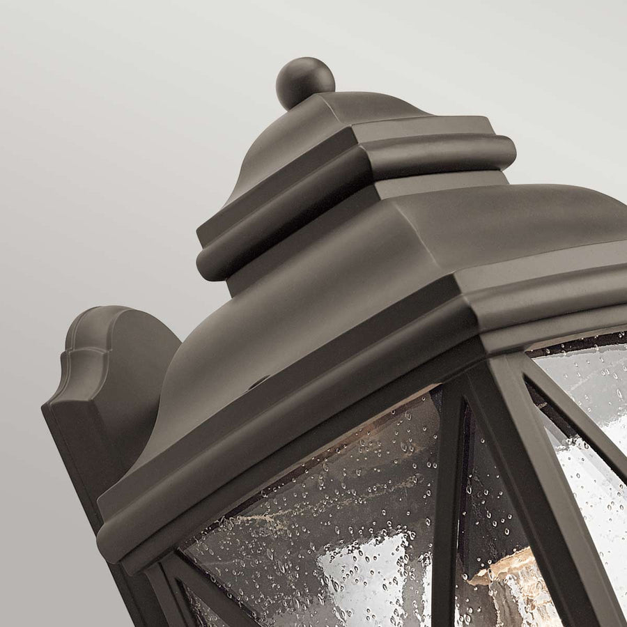 Détail du sommet bombé, de la couronne moulurée et du support mural en bronze foncé