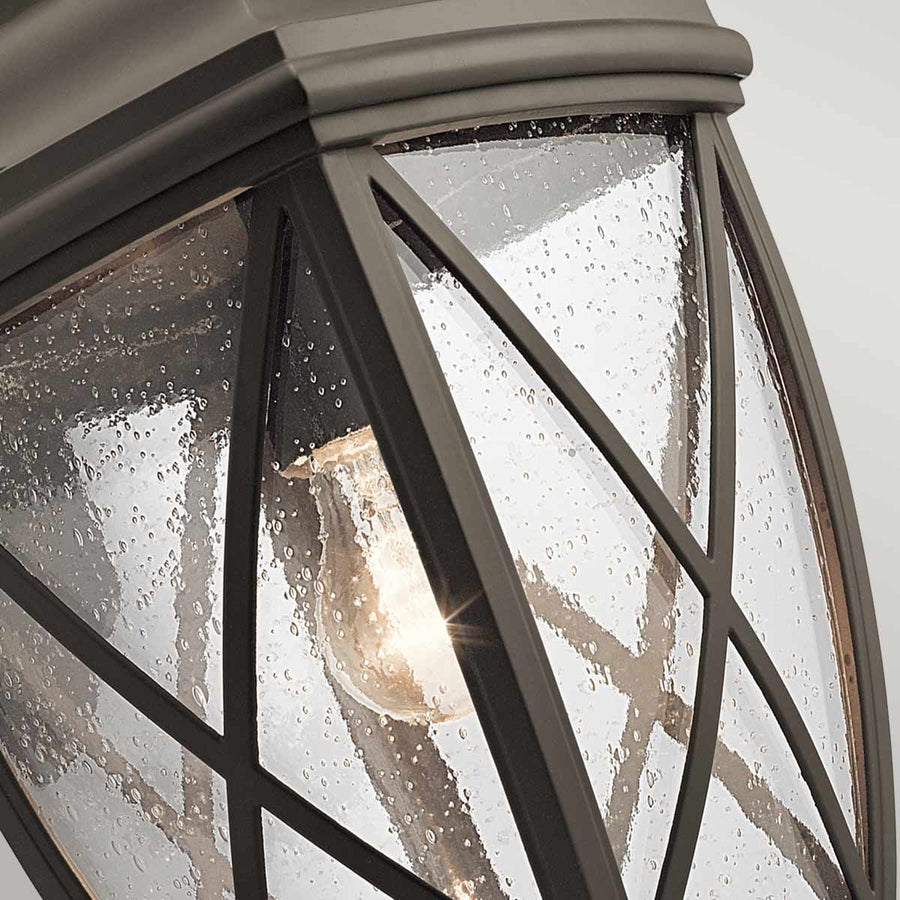 Vue rapprochée d'un angle du verre moucheté laissant apparaître l'ampoule allumée