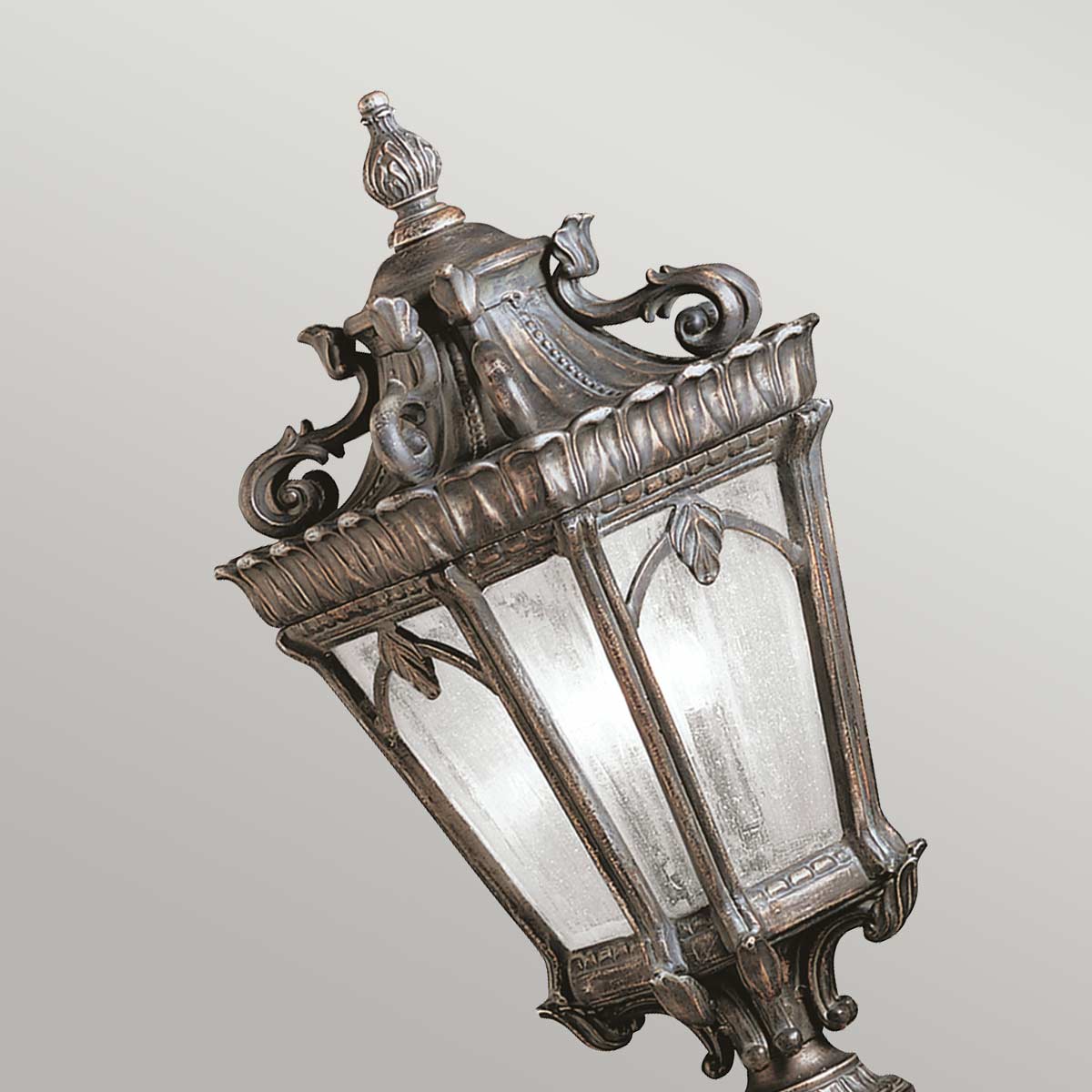 Gros plan incliné du sommet de la lanterne, finition bronze et verre.