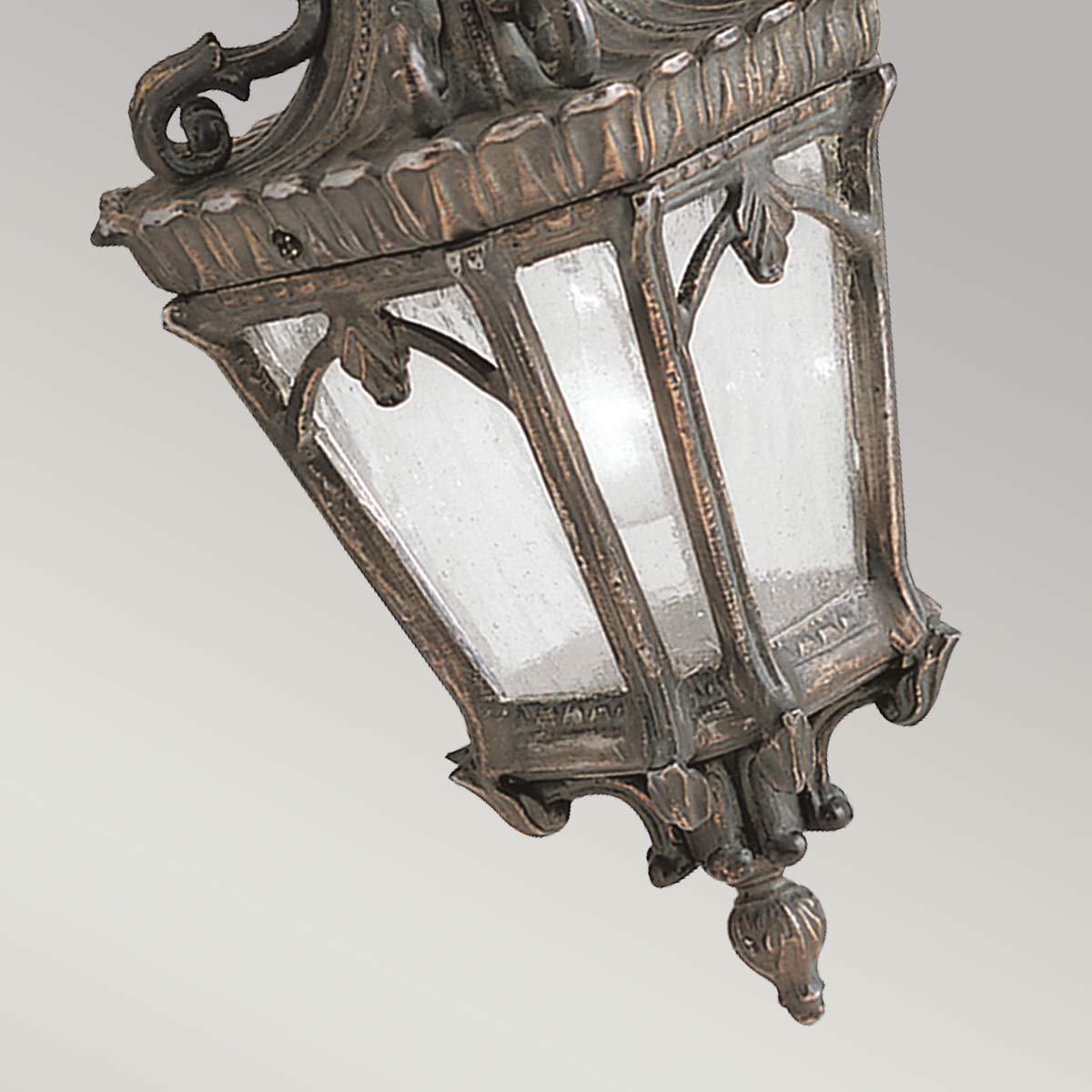 Détail du bas du luminaire, verre texturé et finition métallique patinée.