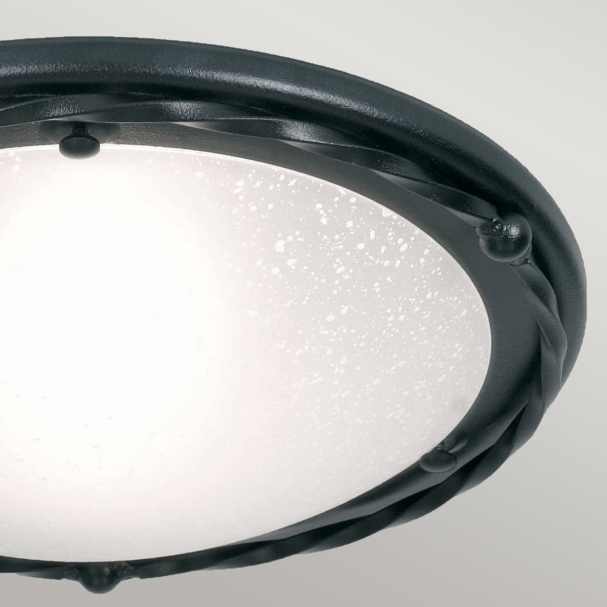 Gros plan sur la fixation et le motif torsadé du luminaire rond