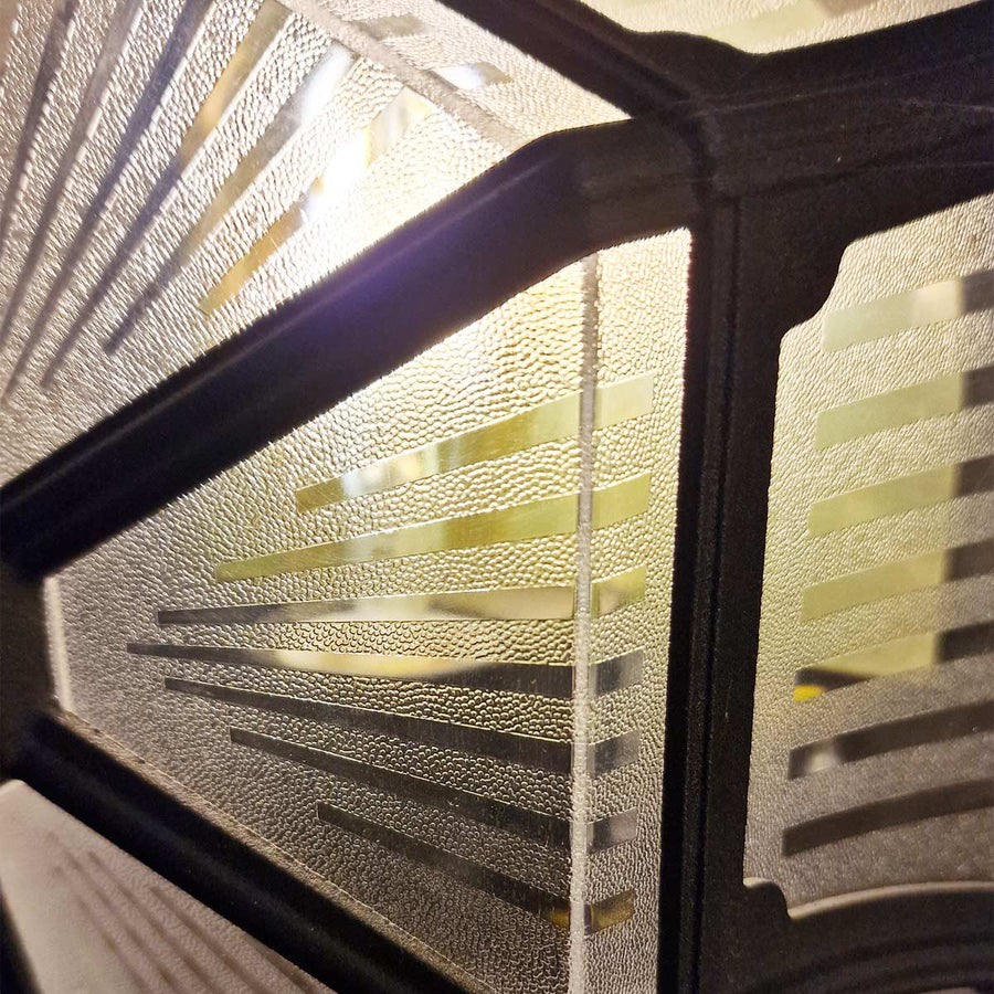 Vue rapprochée des motifs géométriques du verre rétroéclairé.