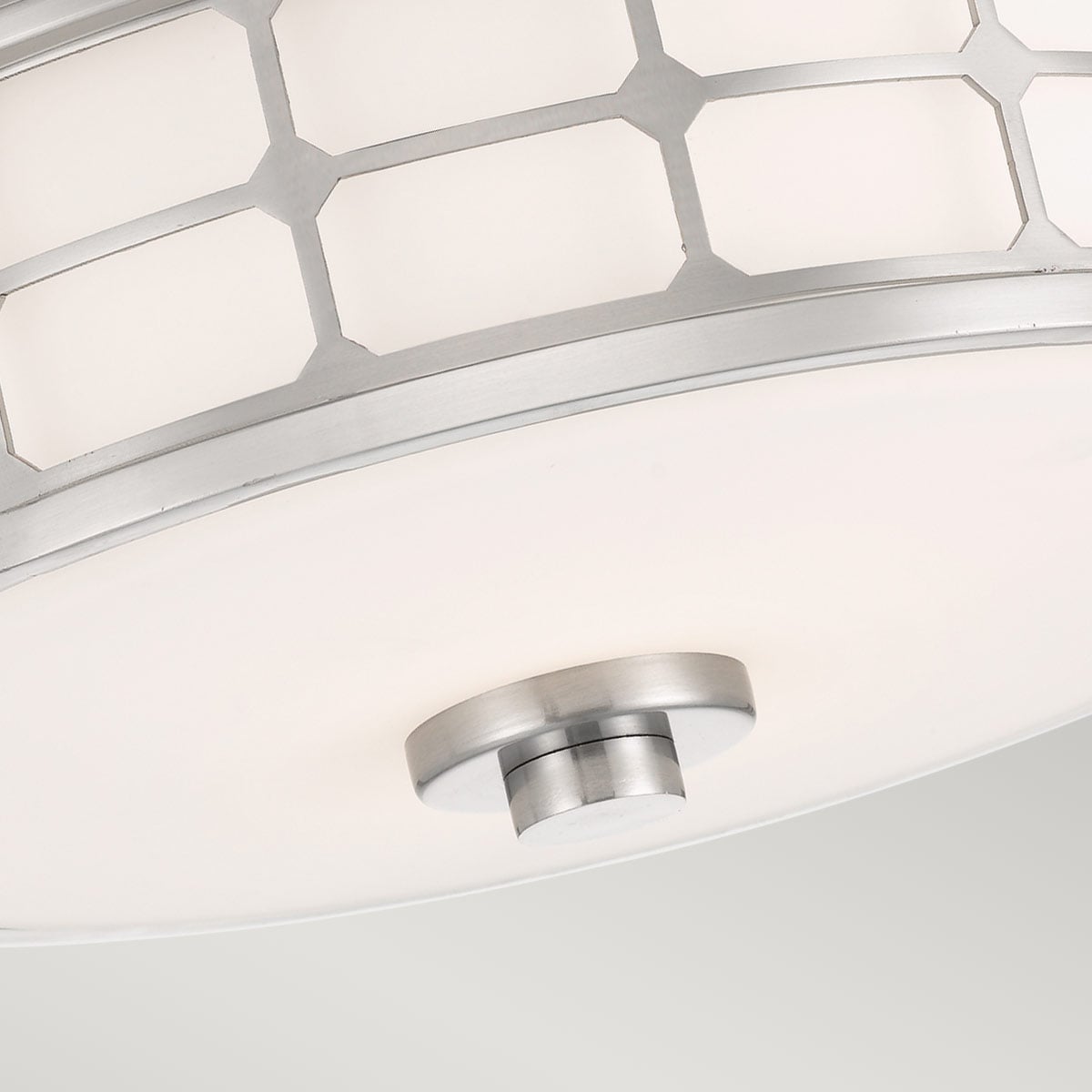 Gros plan sur le bas du luminaire, montrant le diffuseur et le bouton central.