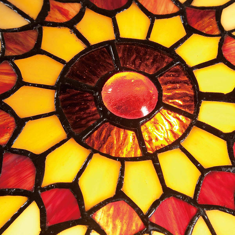 Gros plan du verre coloré, rosace rouge centrale et motifs en pétales sertis de plomb