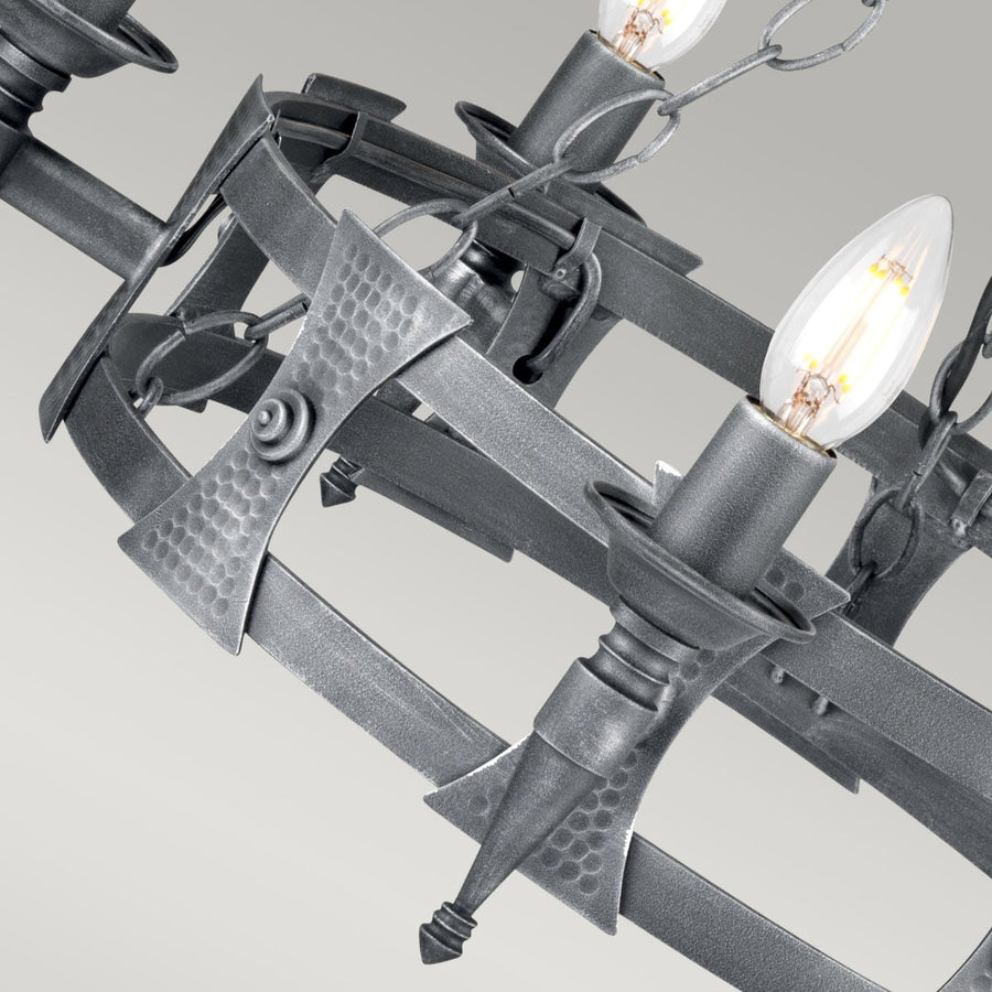 Gros plan sur la finition martelée, les rivets et le support des douilles de ce lustre.