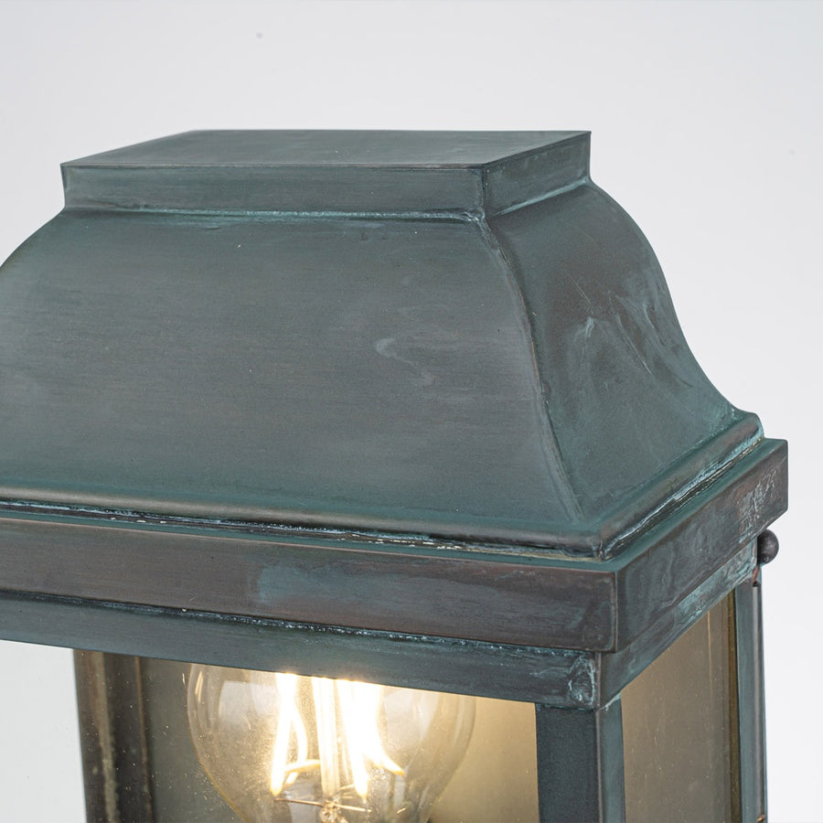Vue rapprochée du chapeau bombé et de la patine vert-de-gris du luminaire