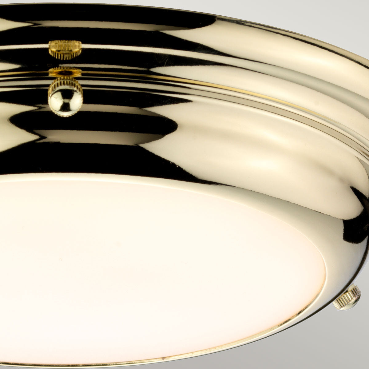 Détail du cabochon central doré reflétant la lumière sur le laiton poli