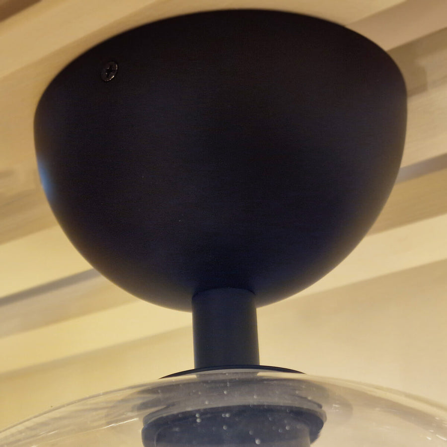 Vue rapprochée de la rosace noire mate fixée au plafond avec vis apparente
