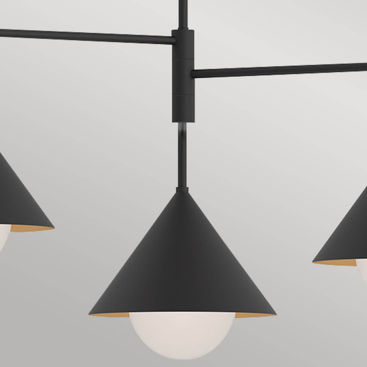 Détail du moyeu central et des bras métalliques noirs supportant les trois luminaires.