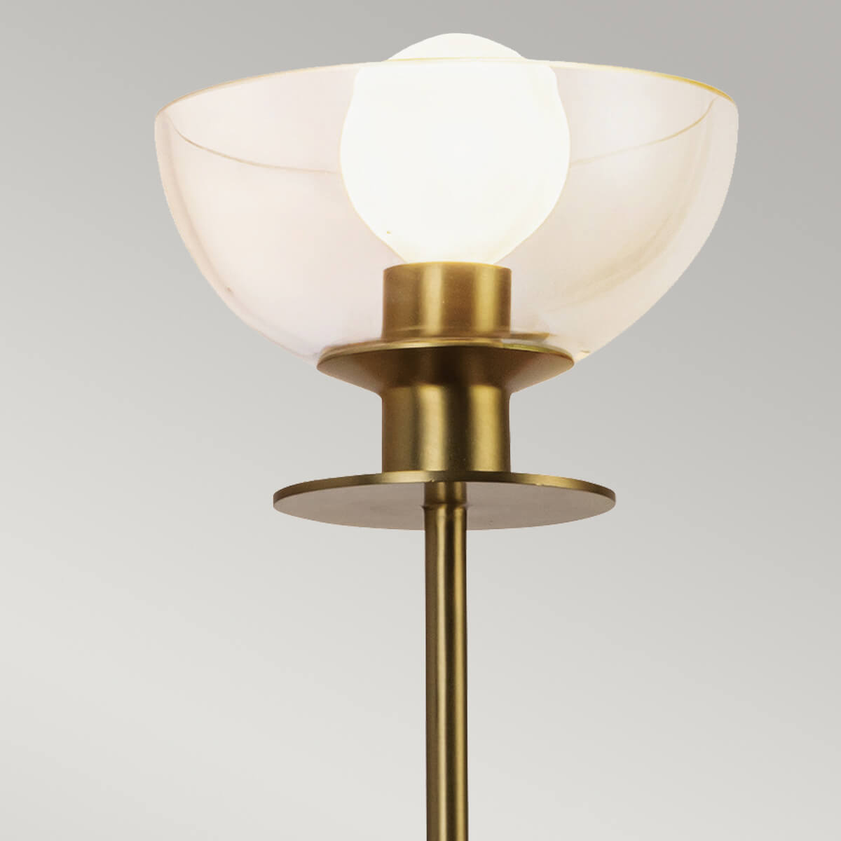 Détail du verre bombé et de la douille dorée avec ampoule allumée