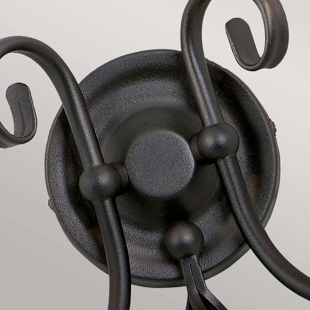 Détail du support central rond et des bras recourbés en métal noir