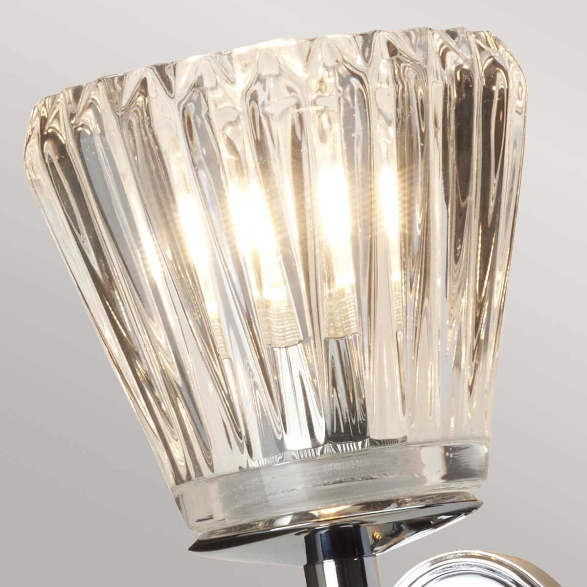 Gros plan sur le verre strié du diffuseur, ampoule allumée visible à l'intérieur