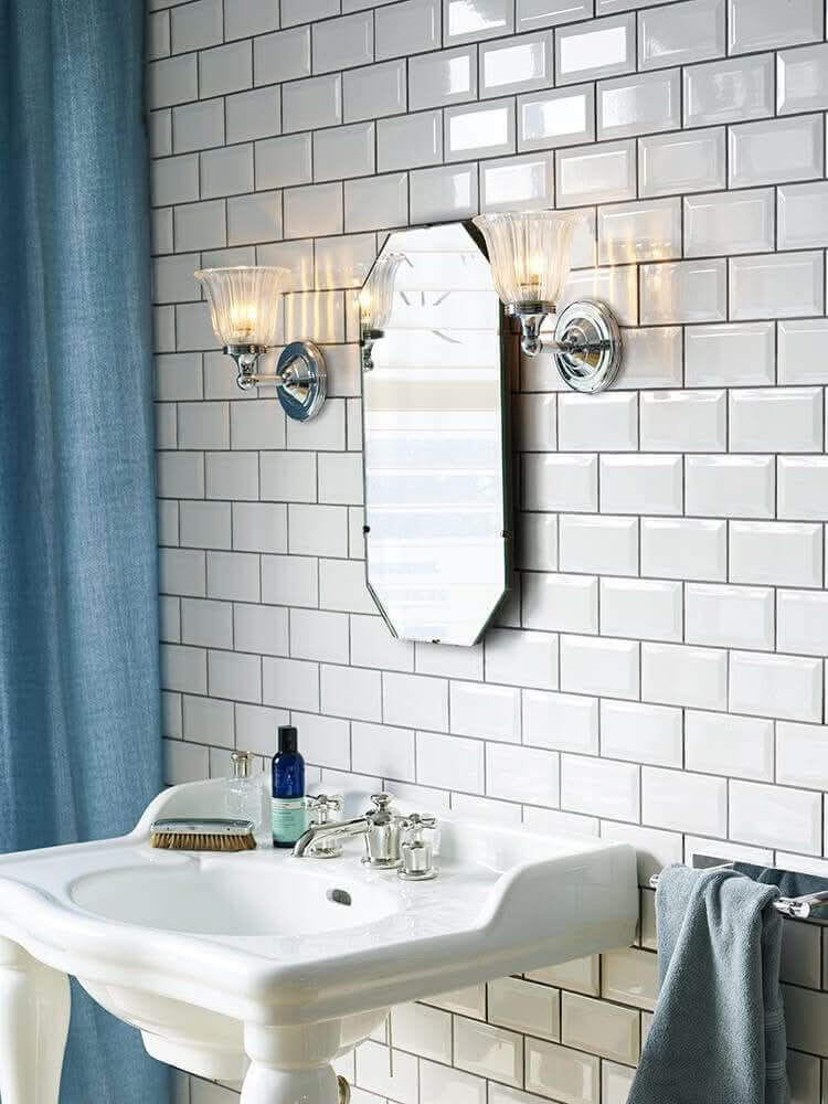 Mise en ambiance dans une salle de bain, deux appliques encadrant un miroir et un lavabo