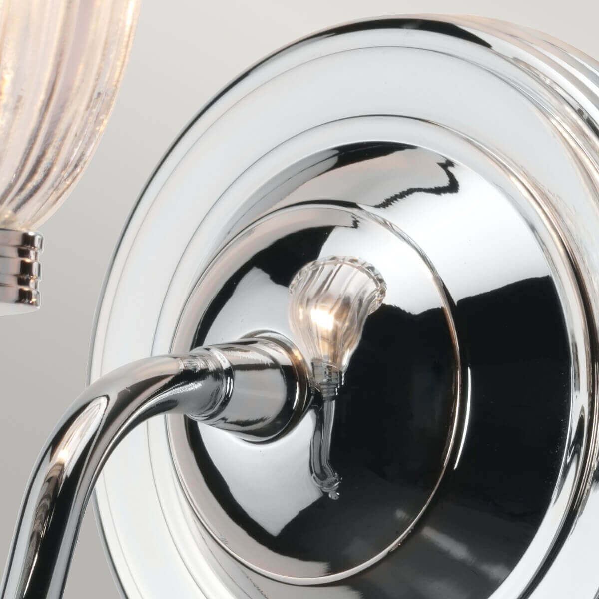 Détail du plateau mural rond et du bras courbe en chrome poli très réfléchissant