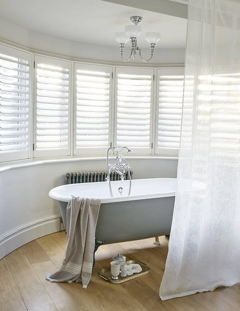Mise en ambiance dans une salle de bain, luminaire suspendu au-dessus d'une baignoire îlot