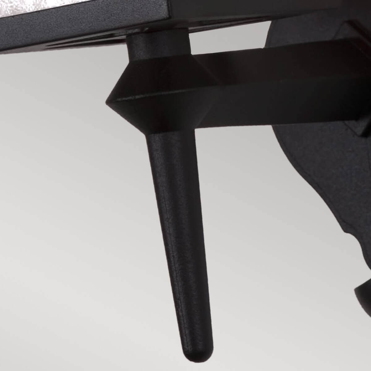 Détail du bras de fixation noir et de la tige verticale sous le boîtier