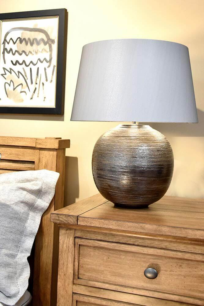 Plan serré sur la base boule brillante et l'abat-jour, chambre en ambiance chaude