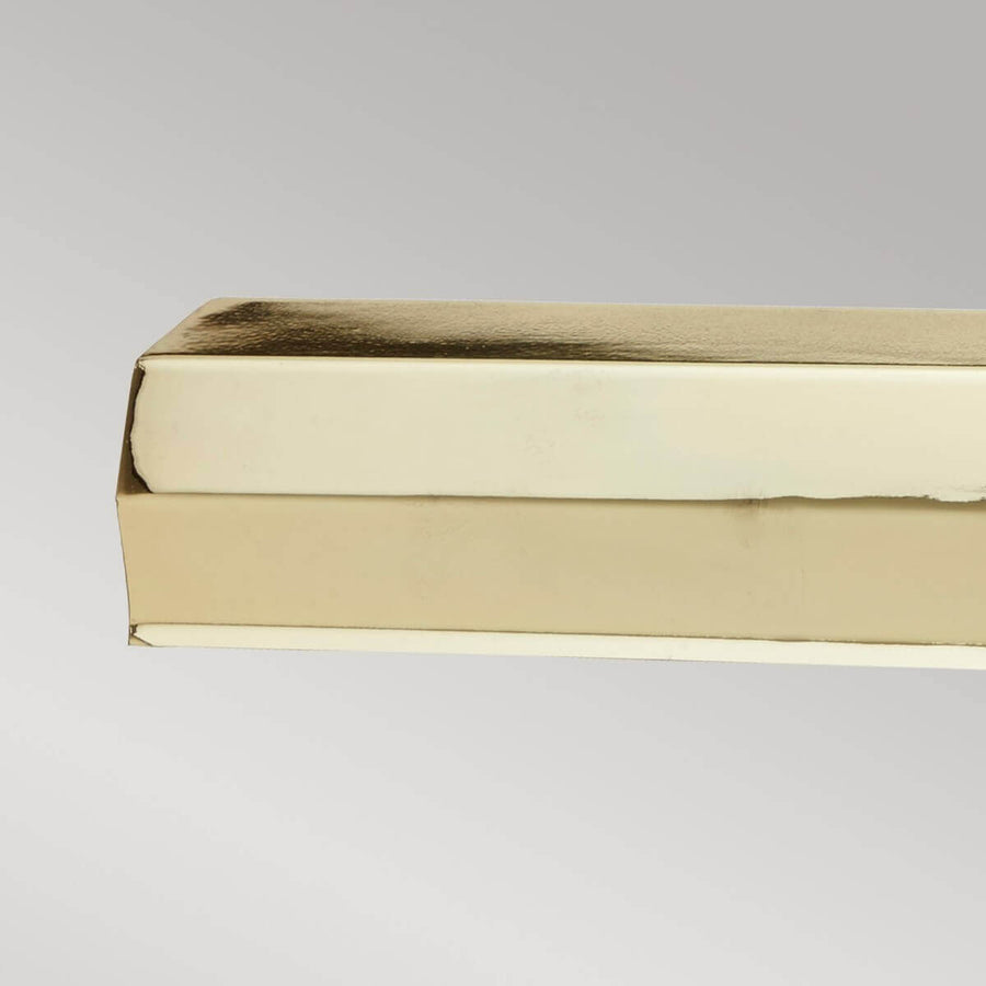 Gros plan sur l’extrémité du bandeau rectangulaire et ses lignes en laiton poli.