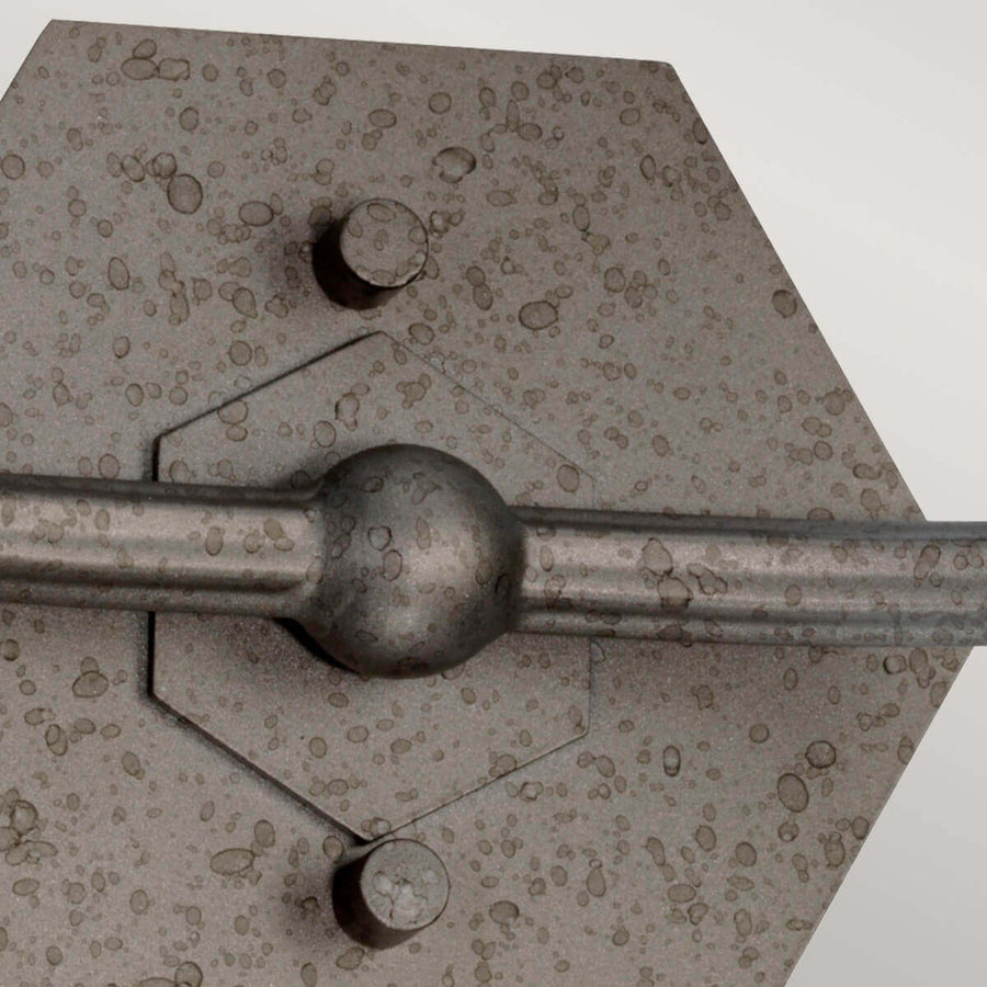 Gros plan sur la platine hexagonale martelée et ses deux vis de fixation