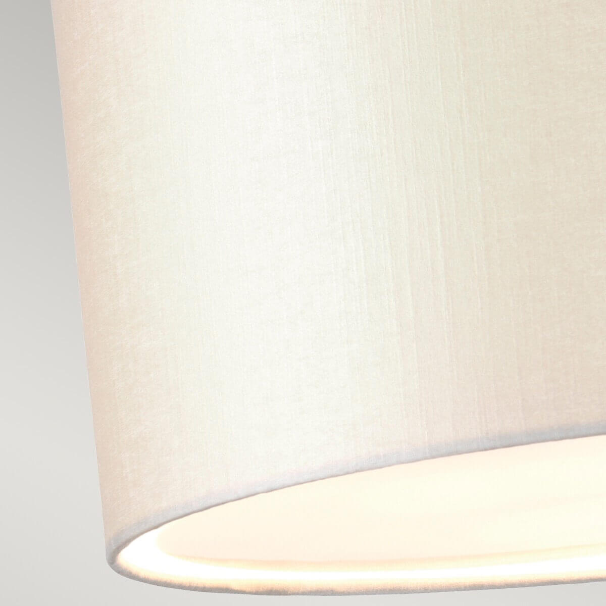 Gros plan sur la texture tissée de l'abat-jour crème et le diffuseur inférieur.