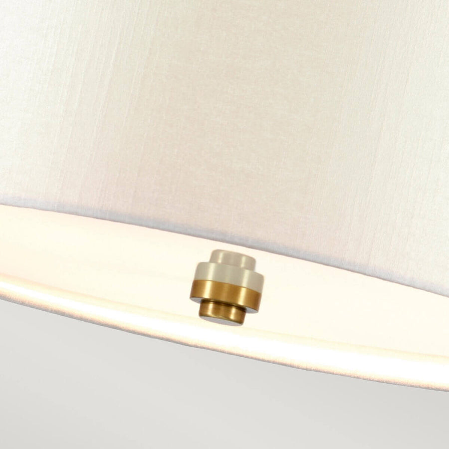 Gros plan du cabochon central fixé sous le diffuseur blanc, liseré laiton