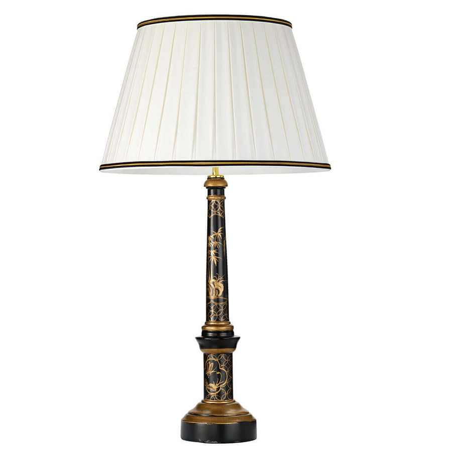 Vue rapprochée du luminaire montrant le décor doré du fût noir et la base