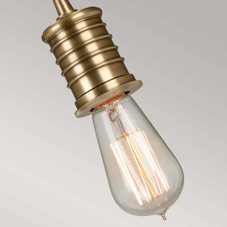 Vue rapprochée de l'ampoule Edison allumée sous la douille en laiton