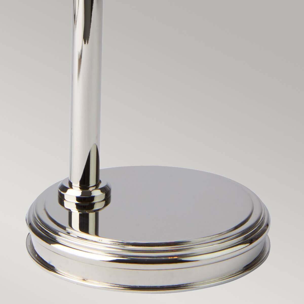 Détail de la base ronde et polie en nickel, avec la tige verticale fixée.