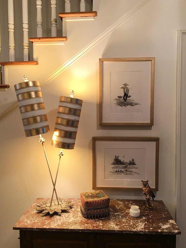 Mise en ambiance nocturne, lampe à deux abat-jours rayés posée sur une commode