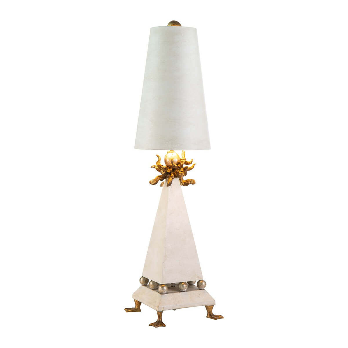 Lampe à poser de face sur fond blanc, abat-jour crème et base triangulaire dorée.