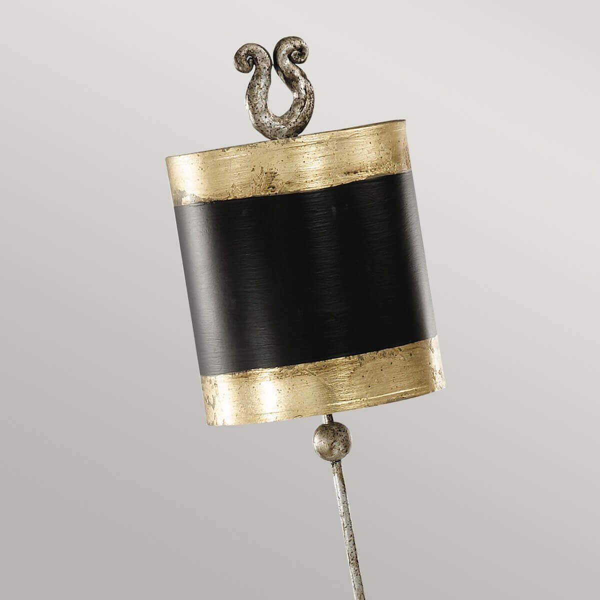Détail du haut de l'abat-jour cylindrique noir, bandes dorées et finition métallique.