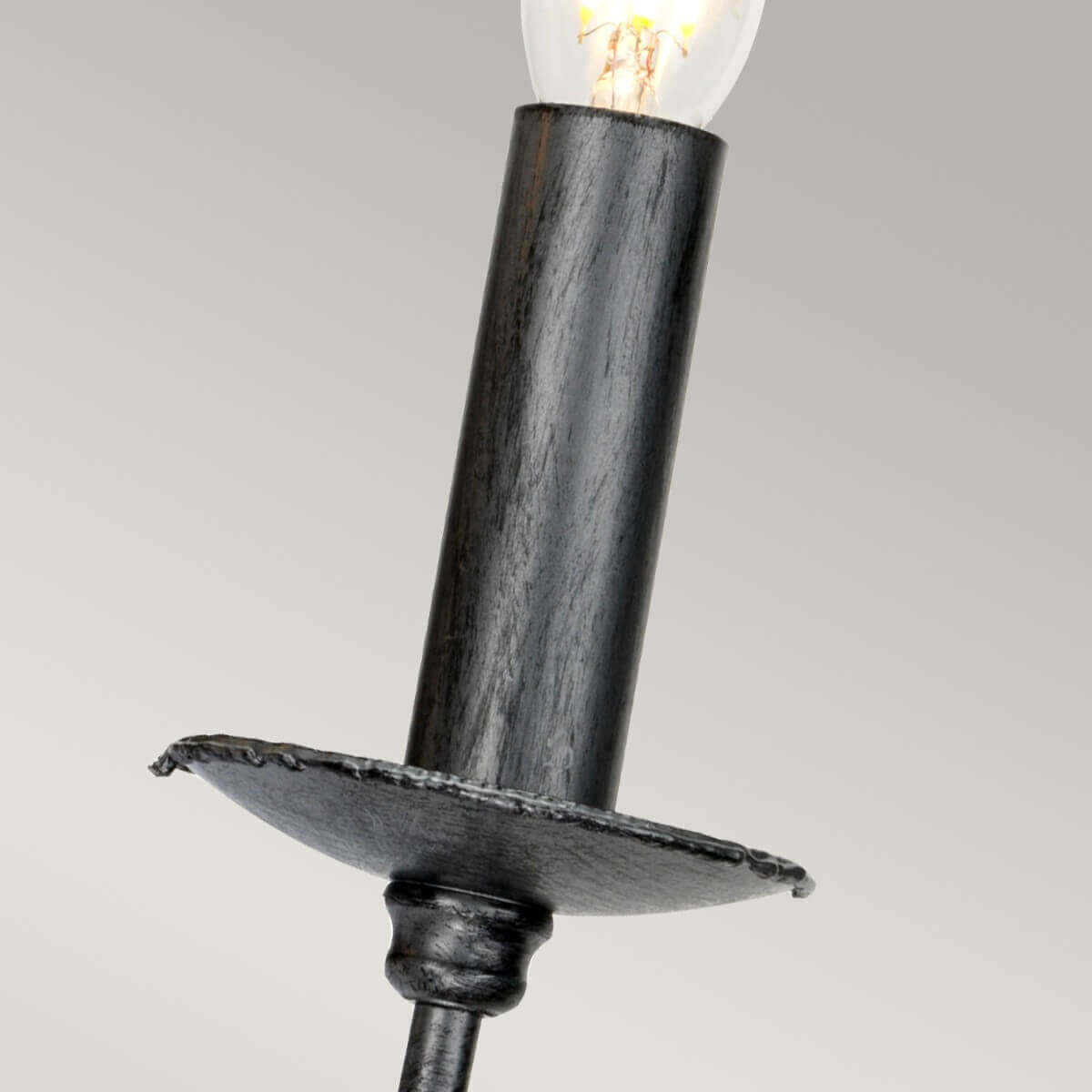 Détail d'une douille noire en forme de bougie avec coupelle et ampoule