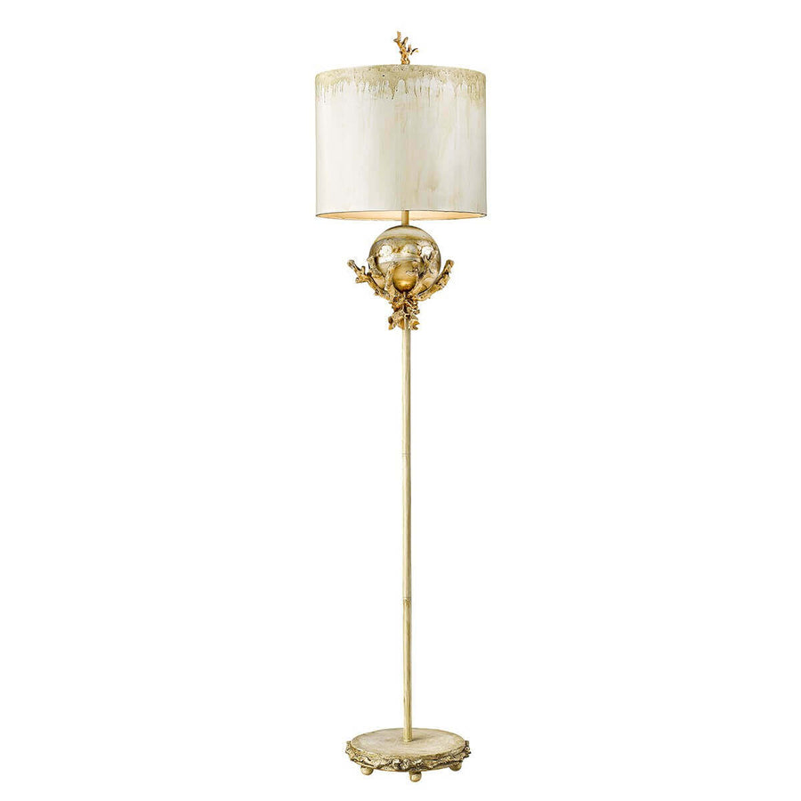 Lampadaire doré de face avec abat-jour blanc et base ronde sculptée.