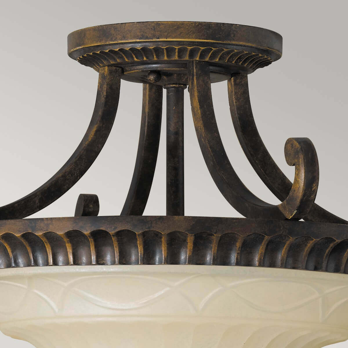 Détail du raccord au plafond et des bras métalliques recourbés, finition bronze vieilli.