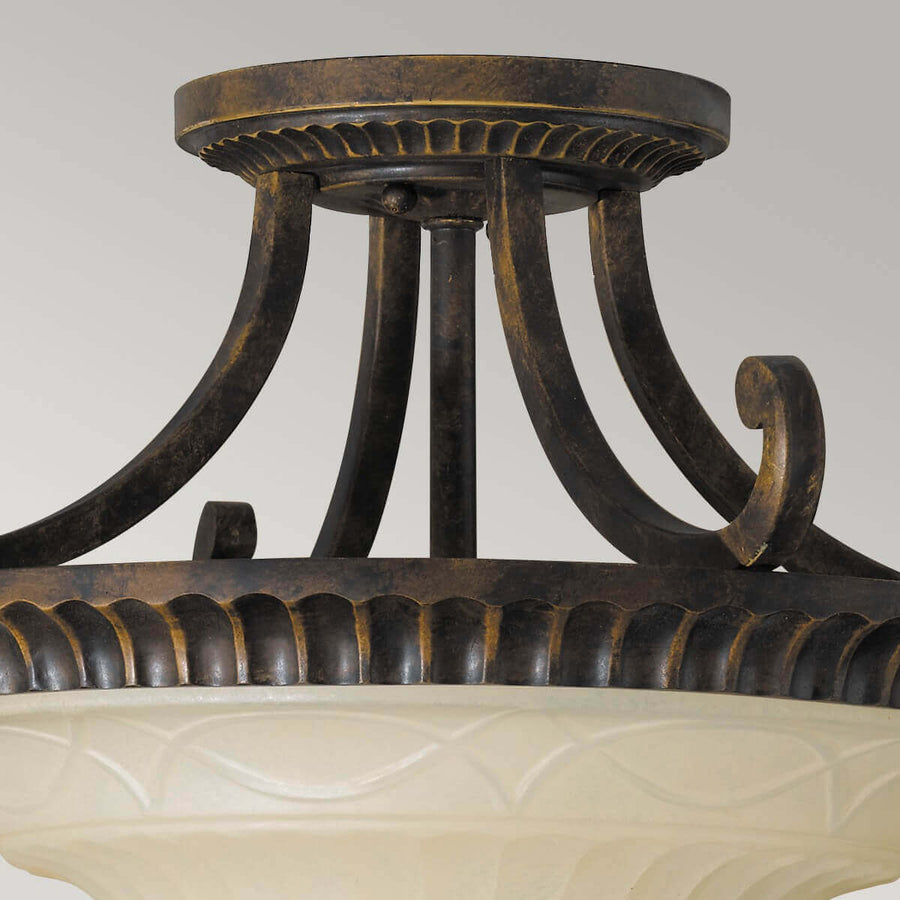 Détail du raccord au plafond et des bras métalliques recourbés, finition bronze vieilli.