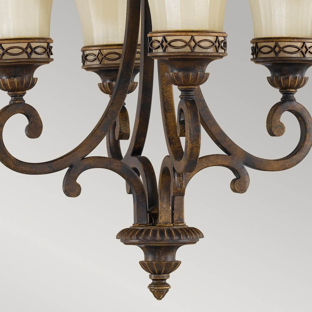 Détail du bas du lustre, bras recourbés et finition métallique patinée.