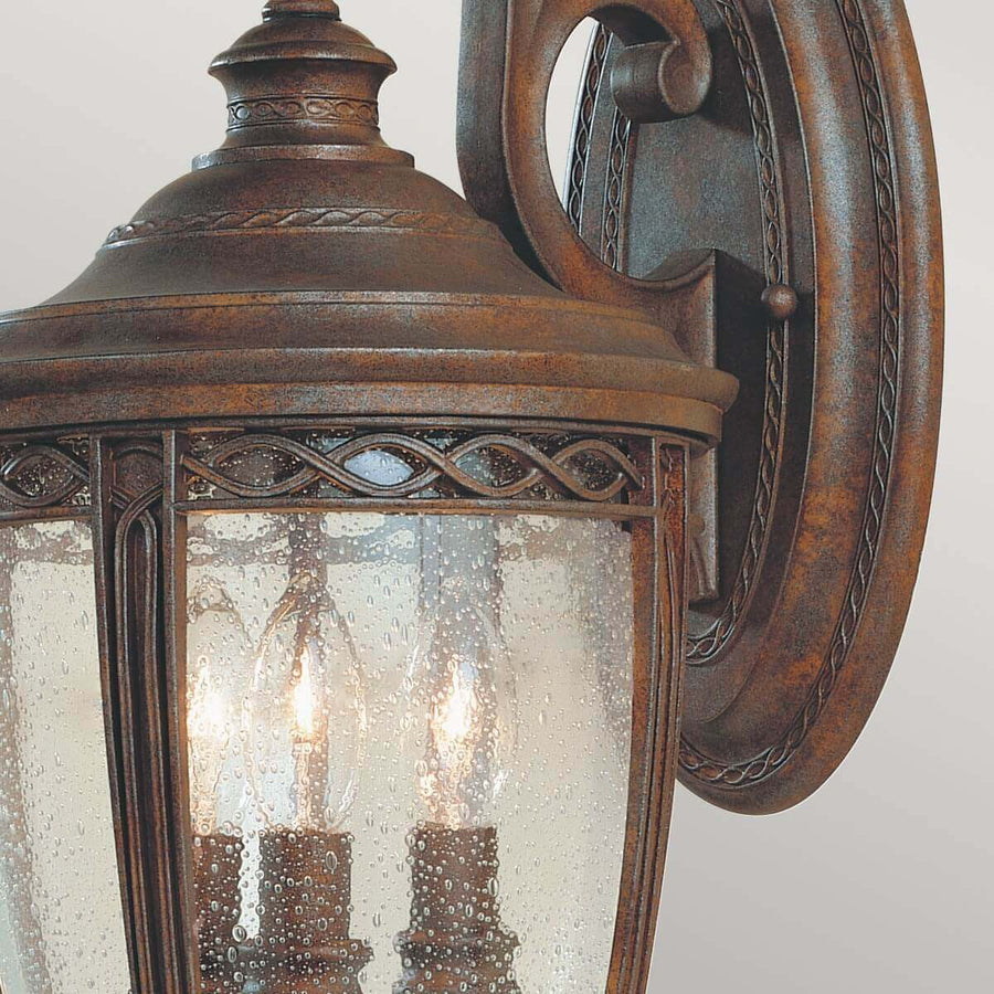 Détail du bras sculpté et de la verrière mouillée, finition bronze vieilli et décor tressé.