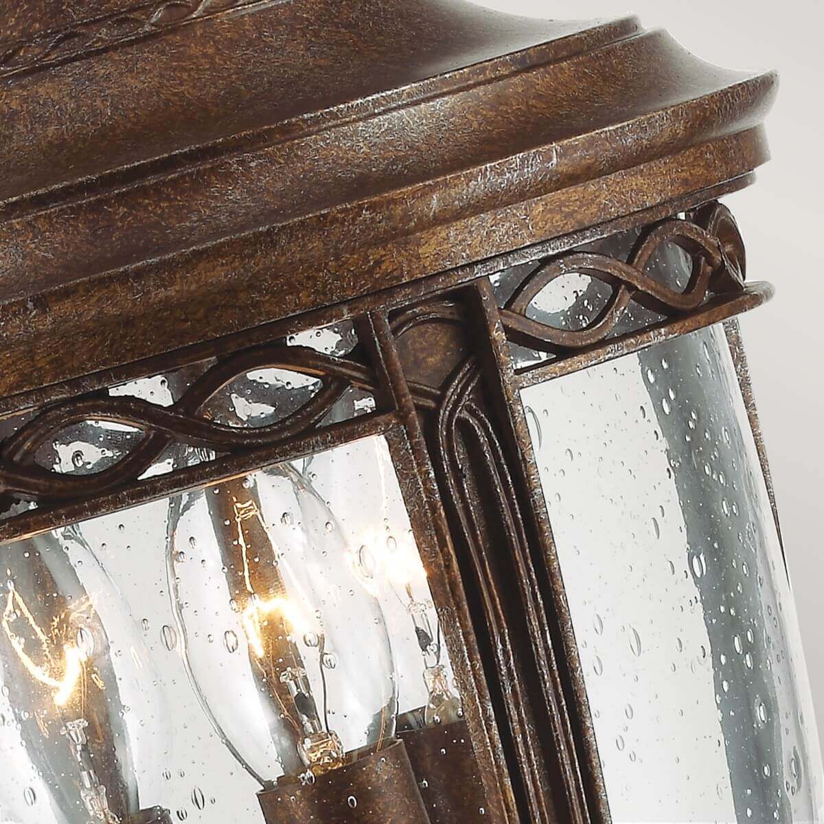 Détail du haut du luminaire avec verre moucheté et trois ampoules visibles