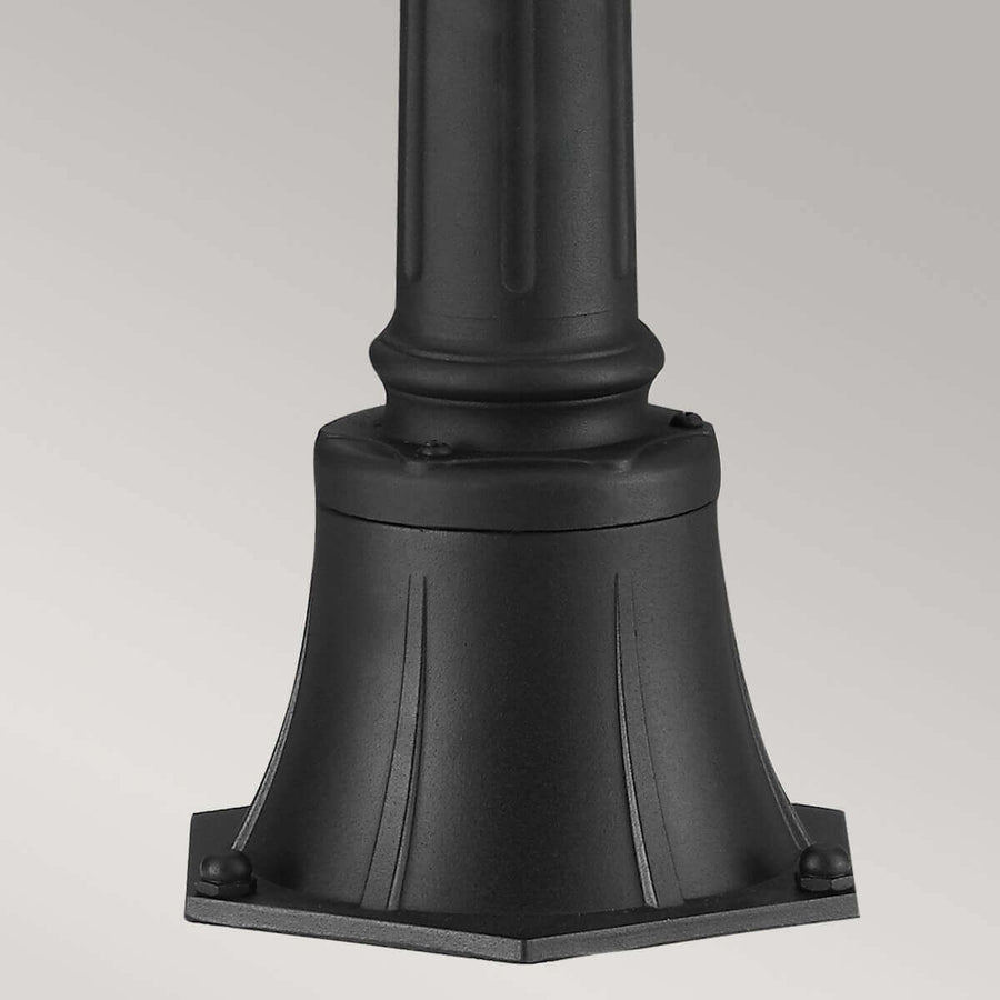 Détail de la base moulurée du lampadaire avec boulons de fixation au sol
