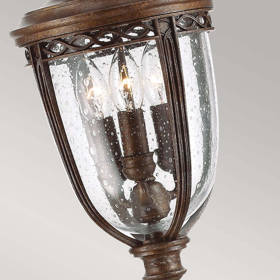 Gros plan du bas de la lanterne, verre gouttelettes et trois ampoules à flamme visibles.