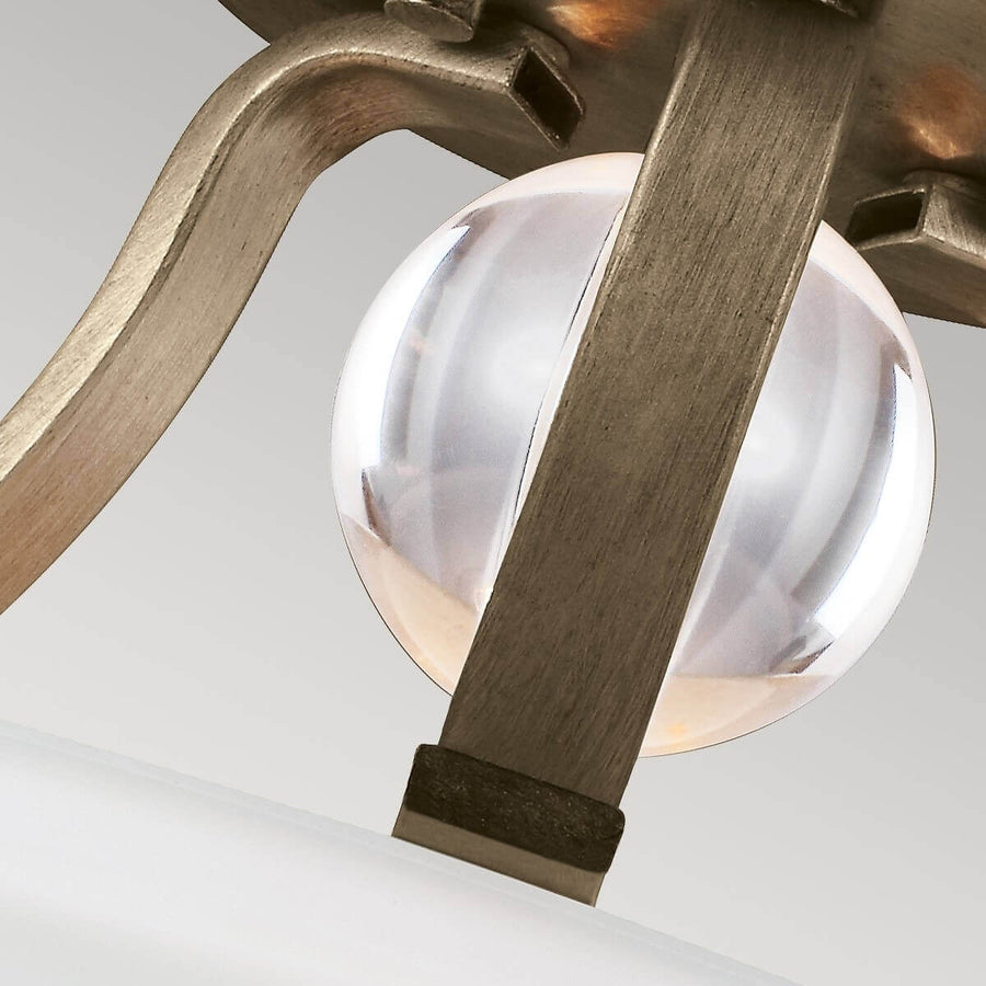 Gros plan sur la sphère de verre clair maintenue par un lien métallique