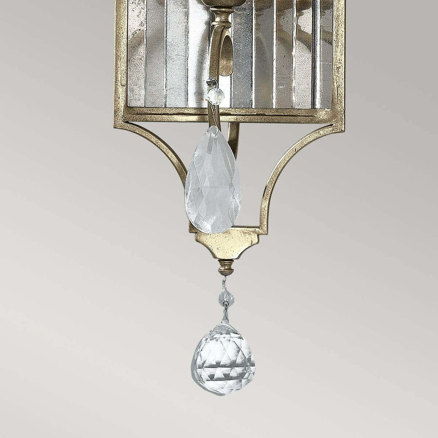 Détail de la base avec goutte de cristal taillée et petit pendentif.