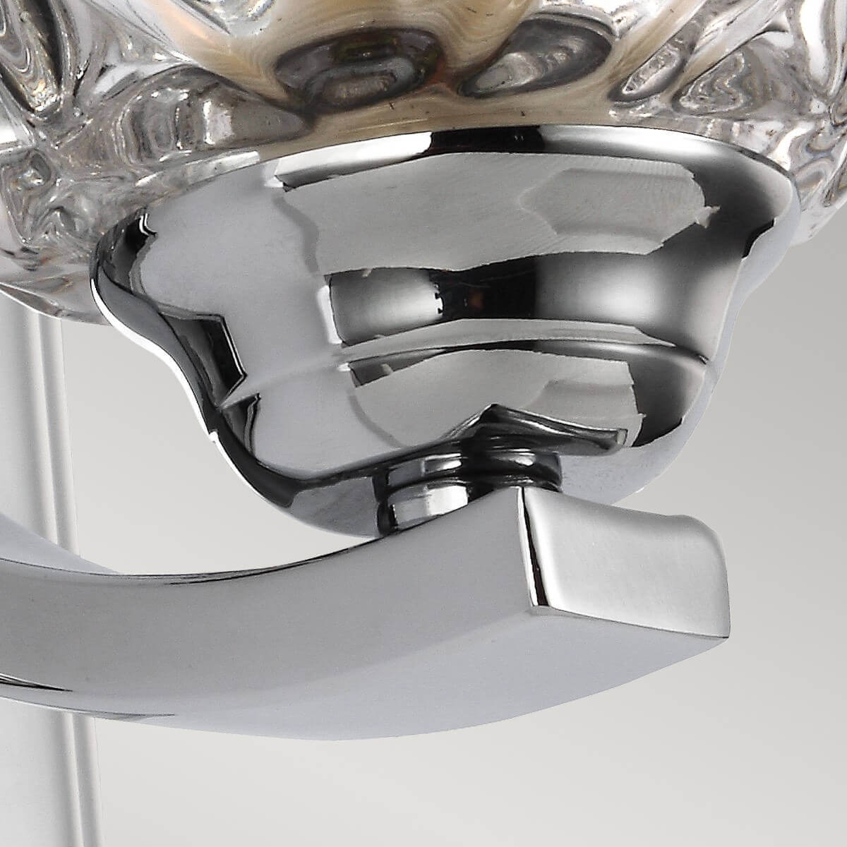 Détail du bras incurvé chromé et de la bague sous la verrine