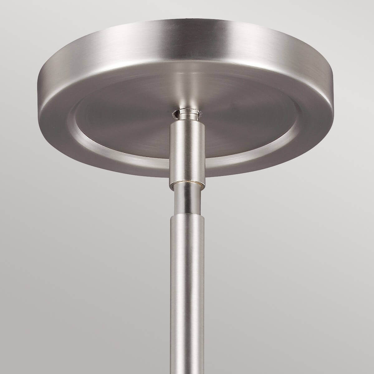 Détail de la fixation circulaire au plafond en métal nickel satiné brossé.